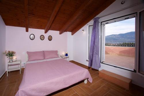 a bedroom with a bed and a large window at Kazarma Luxury Apartment at Klismata village 8 guests in Spartià