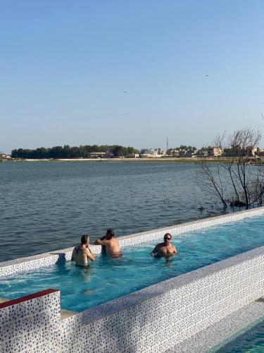 three men in a swimming pool in the water at Hotel le Trarza in Niaga