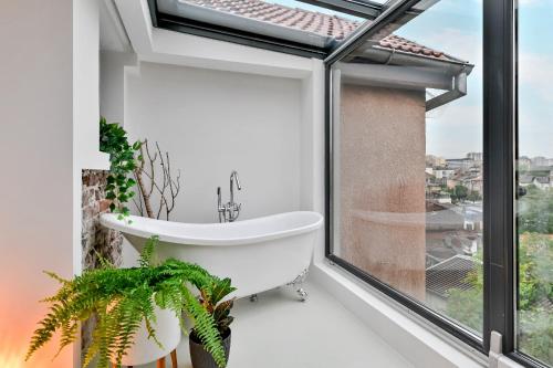 a bath tub in a bathroom with a window at Dreamy Sunset Loft in Sofia City Center in Sofia