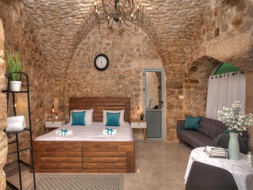 a bedroom with a bed in a stone wall at קשתות - מתחם אבן בצפת העתיקה - Kshatot - Stone Complex in Old Tzfat in Safed