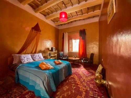 um quarto com uma cama, uma mesa e uma janela em KASBAH ALTAÏR em El Kelaa des Mgouna