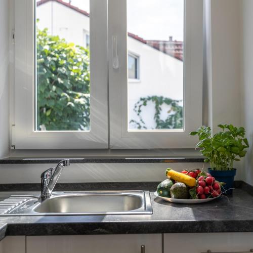 - une assiette de fruits sur un comptoir de cuisine à côté d'un évier dans l'établissement IMMOCITY Apartments Ost, à Darmstadt