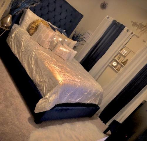 1 dormitorio con cama cubierta de sábanas y almohadas blancas en فندق السعاده, en ‘Izbat Hud.hud