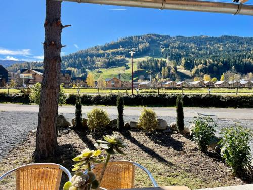 a table and chairs with a view of a mountain at Kreischberg Chalet Ferienpark 3 in Sankt Lorenzen ob Murau
