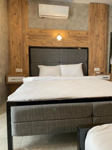 a bedroom with a large bed with a wooden wall at M-ODA OTEL in Antalya
