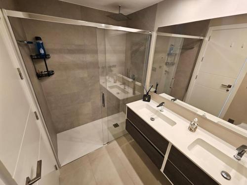 een badkamer met douche, wastafel en spiegel bij Sidi Luxury 2 (Beach & Golf) in Alicante