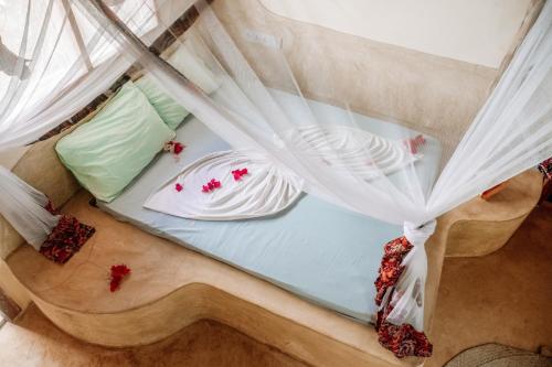 an overhead view of a bed with white curtains at Marvelous Zanzibar in Jambiani