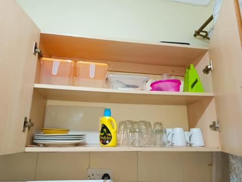 a cupboard with dishes and a bottle of detergent at Kojik Homes in Ngong in Ngong