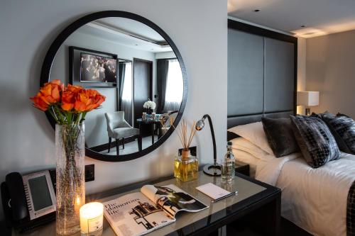 a bedroom with a bed and a table with a mirror at One Warwick Park Hotel in Royal Tunbridge Wells