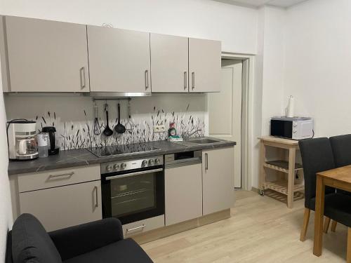 a kitchen with white cabinets and a stove top oven at FeWo Oldaus Nestchen in Oldau