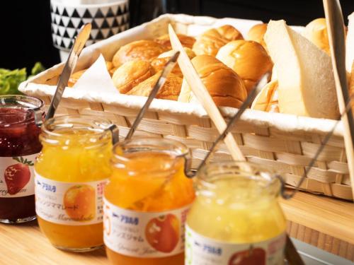 a basket of bread and glasses of orange juice at Hotel AreaOne Kushiro in Kushiro