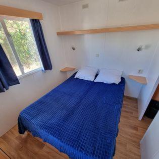 - un lit bleu dans une chambre avec fenêtre dans l'établissement La Cigale Bleue, à Hyères