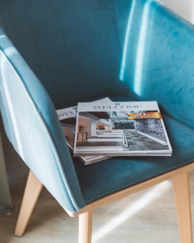 a magazine sitting on top of a blue chair at Athens Cypria Hotel in Athens