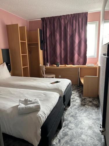 a hotel room with a bed and a window at B&B HOTEL Amiens Centre Cathédrale in Amiens