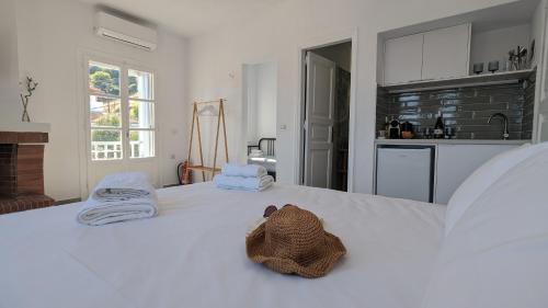 a bedroom with a white bed with towels on it at The Botanist Guesthouse in Skopelos Town