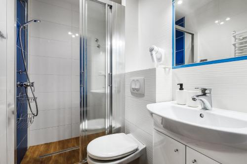a bathroom with a toilet and a sink and a shower at Oliwia in Jastrzębia Góra