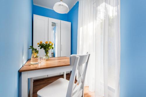 a dining room with blue walls and a table with a white chair at Oliwia in Jastrzębia Góra
