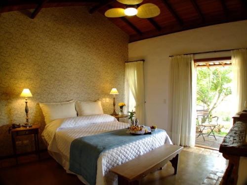 a bedroom with a large bed and a window at Lis Bleu Pousada in Tiradentes