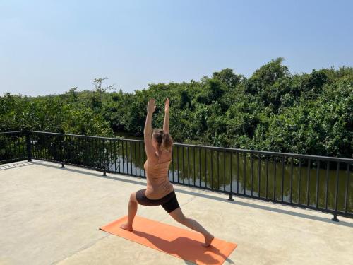 a woman doing a yoga pose on a yoga mat at Bali Villa Mirissa in Mirissa