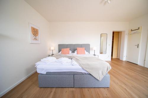 um quarto com uma cama grande e almofadas laranja em Apartment - Central with kitchen - Balcony - Fair em Neuss