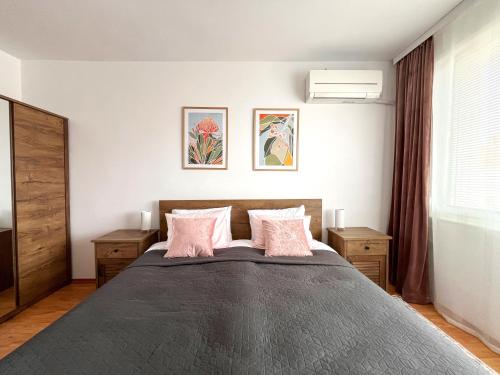 um quarto com uma cama grande e almofadas cor-de-rosa em Апартамент за гости Бажолета - светъл и уютен дом в сърцето на Ямбол em Yambol