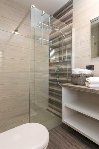 a bathroom with a toilet and a glass shower at Villa Tuta with heated pool, only 150 m from the beach in Pakoštane