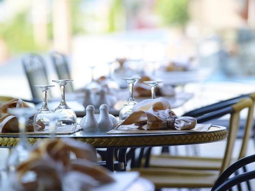 a table with glasses and vases on top of it at Orpheas Resort Hotel (Adults Only) in Georgioupolis