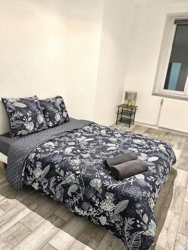 une chambre avec un lit avec une couverture noire et blanche dans l'établissement F3 spacieux au centre ville, à Saint-Étienne