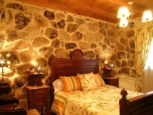 Peñalba de ÁvilaにあるCasa rural a escasa distancia de Ávila by Alterhomeの石壁のベッドルーム(ベッド付)