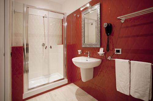 a red bathroom with a sink and a shower at AP 2bd Mayfair in London