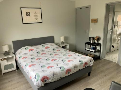 a bedroom with a bed with a floral comforter at Bobs Bnb in Bruges