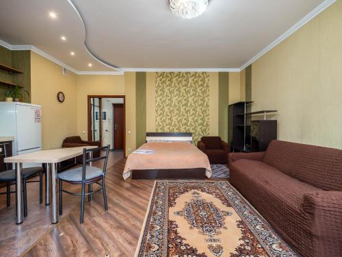 - un salon avec un lit et une table dans l'établissement Однокомнатная квартира-студия, à Almaty