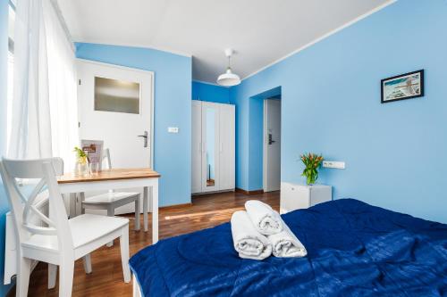 a bedroom with blue walls and a table and a bed at Oliwia in Jastrzębia Góra