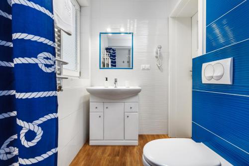 a bathroom with a white sink and a toilet at Oliwia in Jastrzębia Góra