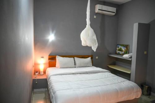 a bedroom with a large bed with a white bedspread at Hotel le Trarza in Niaga