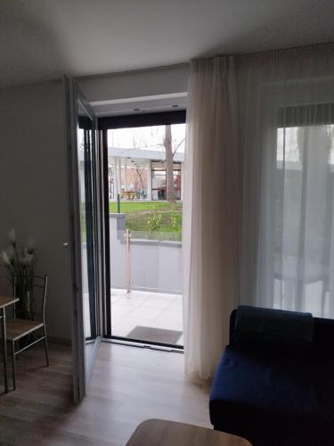 a living room with a couch and a sliding glass door at Beach Home Apartman in Balatonfüred