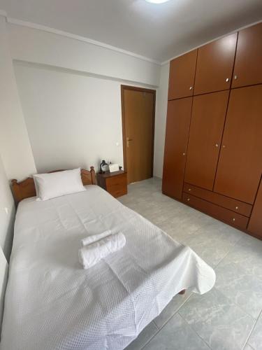 Schlafzimmer mit einem großen weißen Bett und Holzschränken in der Unterkunft Comfortable Apartment With Parking in Thessaloniki