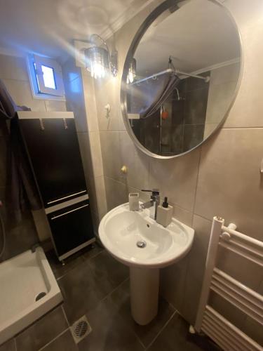 ein Badezimmer mit einem weißen Waschbecken und einem Spiegel in der Unterkunft Comfortable Apartment With Parking in Thessaloniki