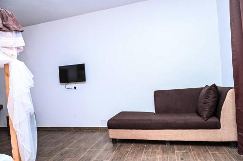 a living room with a couch and a tv at Hotel le Trarza in Niaga