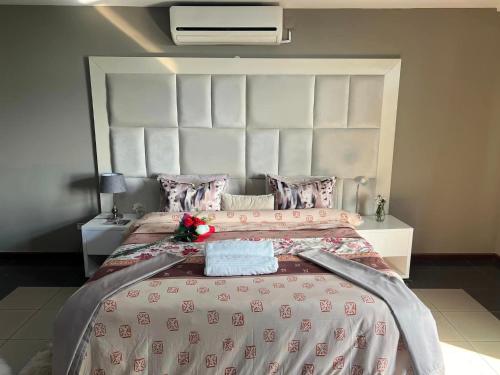 a bedroom with a large bed with a large headboard at MATOLA AcCOMMODATION in Matola