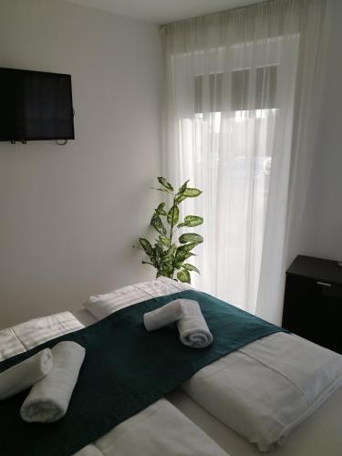 a bedroom with two towels on a bed with a window at Beach Home Apartman in Balatonfüred