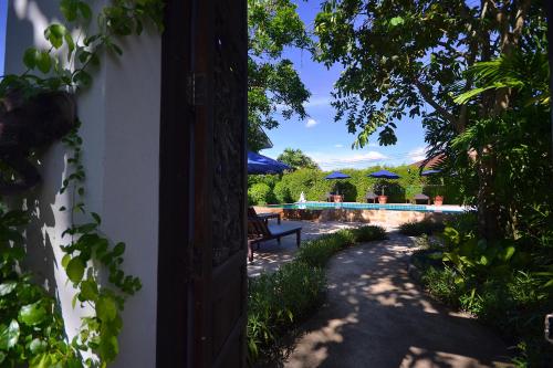an open door to the yard of a house at Thai Thai Sukhothai Resort in Sukhothai