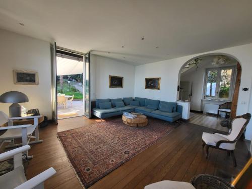 sala de estar con sofá azul y mesa en Villa Adelaide, en Baveno