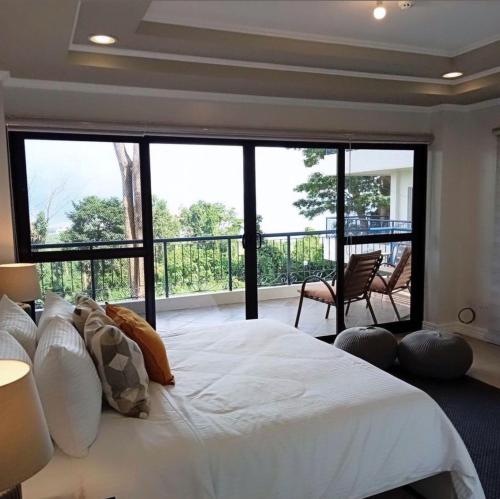 ein Schlafzimmer mit einem großen Bett und einem großen Fenster in der Unterkunft Trillo Bay Villas in Kababae