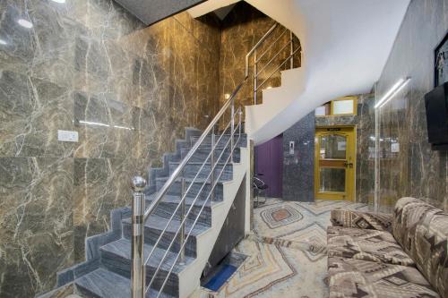 una escalera en una casa con una pared de piedra en Flagship Hotel Ajay, en Jammu