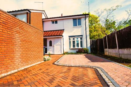 uma entrada de tijolos em frente a uma casa em Spacious White House 3 bedrooms with parking, garden, Wi-Fi em Telford