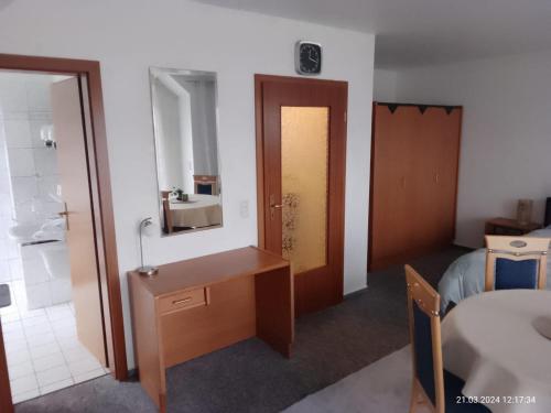 een kamer met een bureau, een bed en een badkamer bij Haus Meyne in Bad Fallingbostel