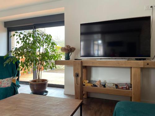 a living room with a flat screen tv on a entertainment center at Maison Valette in Roussillon-en-Morvan