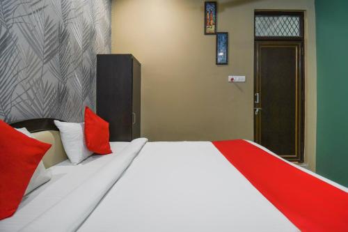een slaapkamer met een groot bed met rode kussens bij OYO Jk Mahal in Sūbedārganj