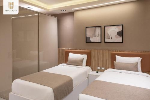 two beds sitting next to each other in a room at Homztality Elbatal Mohandeseen in Cairo